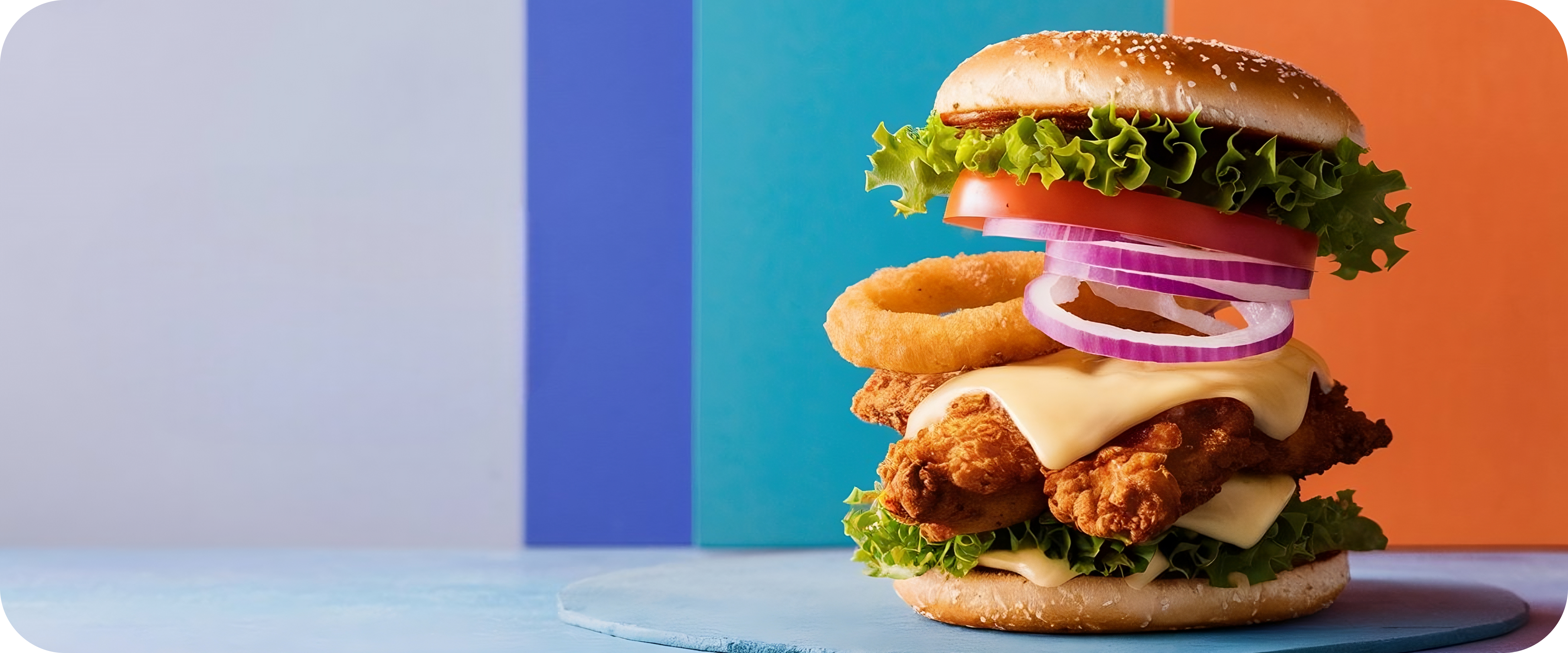 Delicious chicken burger with onion rings and fresh vegetables on a colorful background